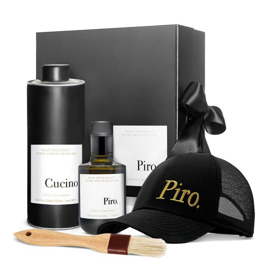 A gift box with a black hat that has 'Piro' written on it, a bottle labeled 'Piro', a smaller bottle labeled 'Cucino', and a wooden basting brush.
